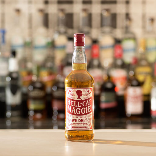 A bottle of whiskey in a wood room on a wood table