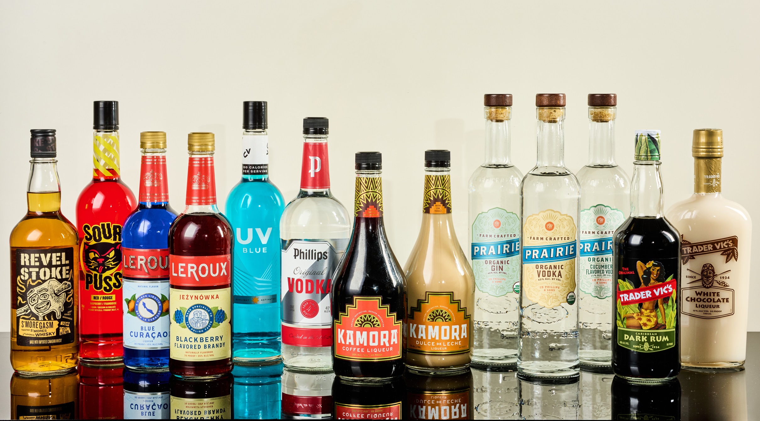 A line of alcohol bottles on a bar with a plaid background